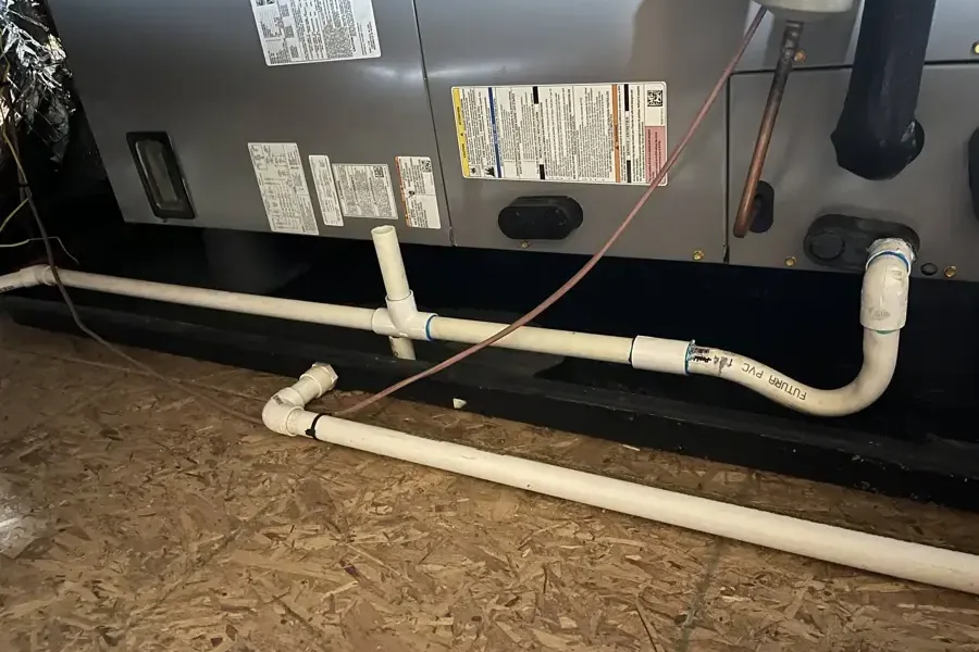 An air handler with PVC condensate drain piping attached