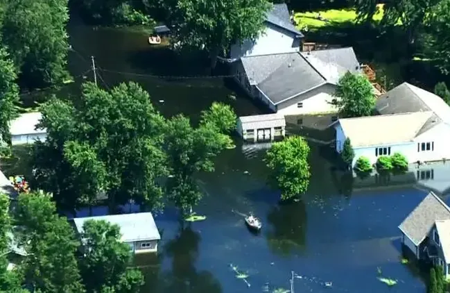 River flood water surrounding houses and trees, seen from above